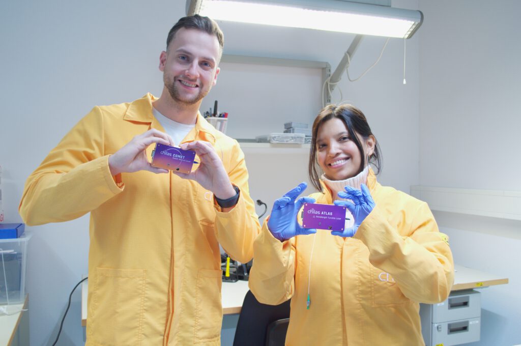 Two people in a laboratory holding Chilas COMET and ATLAS laser modules.
